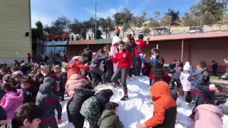 Kamyonla okul bahçesine taşınan kar, öğrencilerin neşe kaynağı oldu