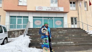 Karla kaplı yolda işine snowbordla kayarak gitti