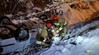 Karlı yolda sulama kanalına düşen otomobil ters döndü