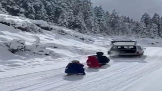 Kızakları aracının arkasına bağladı, çocuklarını doyasıya eğlendirdi