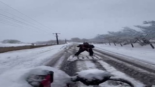 Yağışı eğlenceye dönüştürdü: Karla kaplı yolda ahşap paletle kayak yaptı