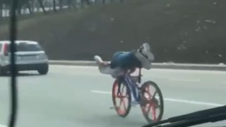 Bisikletin üzerinde uzanarak giden gençler trafiği tehlikeye attı