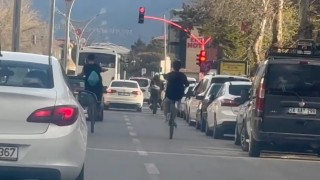 Bisikletle tek teker üzerine giden gençler trafiği tehlikeye düşürüyor