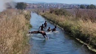 Çifte tehlike: Yangına rağmen su kanalındaki oyunlarını bozmadılar