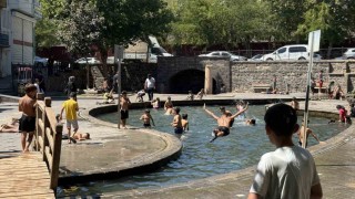 Sıcak havada kavrulan çocuklar, süs havuzunda serinliyor