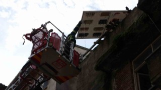 Çatıdan tehlikeli şekilde sarkan pano, itfaiye ekiplerince kaldırıldı