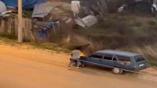 Alev alev yanan aracını kovayla su döküp söndürdü