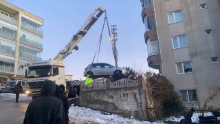 Buzlanan yolda kayan otomobil apartmanın bahçesine düştü