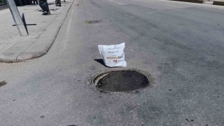 Çöken rögar kapağını gören vatandaş poşetle önlem aldı