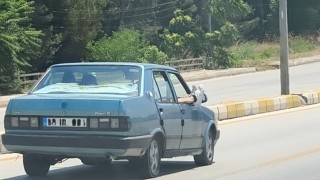 Ayaklarını camdan dışarı çıkartan yolcu trafiği riske attı