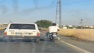 Otoyolda tehlikeli yolculuk: Motosiklet, otomobil kemerine tutunarak ilerledi