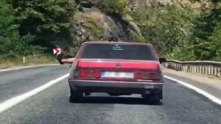 Ayaklarını camdan sarkıtarak trafiği tehlikeye attı