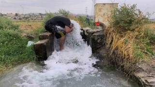Kavurucu sıcakta elbisesini bile çıkarmadan buz gibi sondaj suyunda serinledi