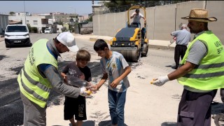 Kurtalanda kavurucu sıcakta çalışan belediye ekiplerine çocuklardan soğuk su ikramı