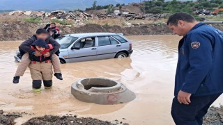 İtfaiyeci, göle dönen yolda mahsur kalan çocuğu sırtında taşıyarak kurtardı